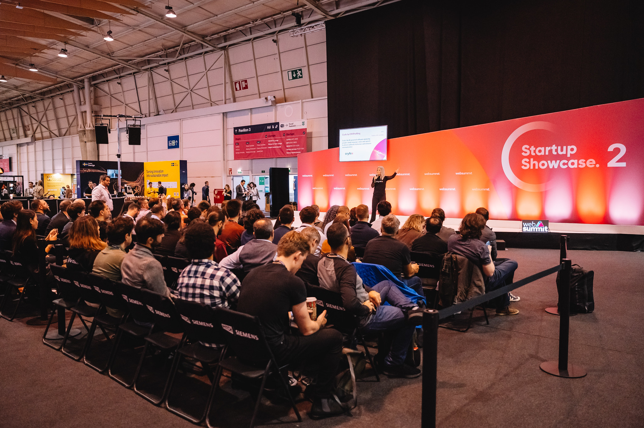 Audience watches speaker at stage during Startup Showcase